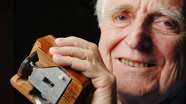 Doug Engelbart holding one of the first mouse prototypes